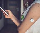 continuous glucose monitor on woman arm