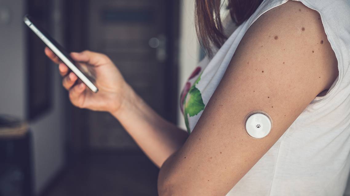 continuous glucose monitor on woman arm